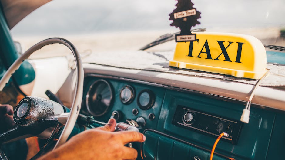 Interior view of a classic Cuban taxi with vintage steering wheel and taxi sign.